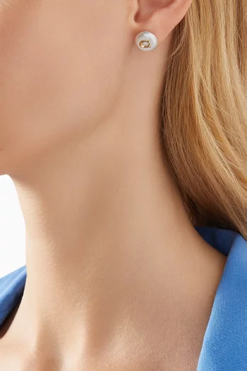 أقراط مزينة بلؤلؤ على شكل عملة معدنية وشعار الماركة معدن