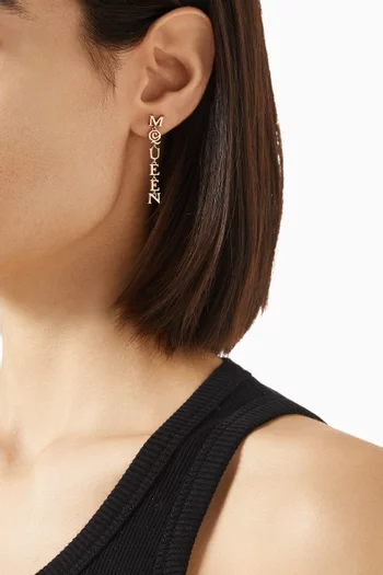 أقراط بتصميم بشعار الماركة نحاس بلون ذهبي